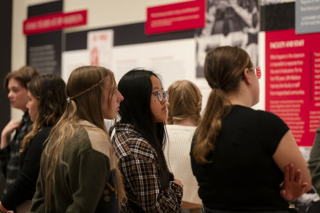 Three woman look intently at an exhibit at the museum.