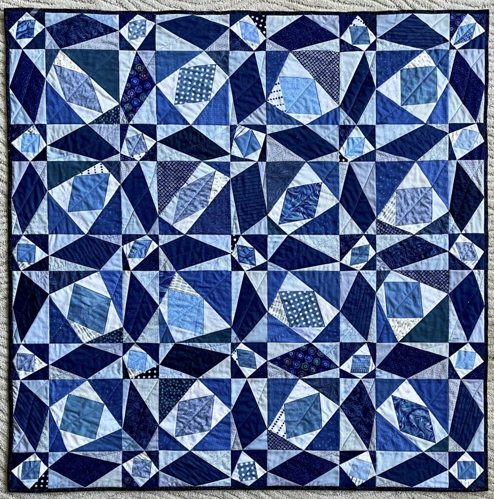 Follow this mathematical thread: The perfect regularity and symmetry of the traditional “Storm at Sea” patchwork has been disrupted in this quilt by shifting, in tandem, neighboring corners of the four-sided shapes in white and navy blue, placing the pairs of offset corners at a random position along the edge of the square or rectangle in which the quadrilaterals are inscribed. The 41 light blue quadrilaterals connect the midpoints of the edges of the white asymmetric quadrilaterals, and each is a visual illustration of Varignon’s Theorem, which proves that its shape must be a parallelogram.
 Amy Wendt,
professor, Electrical and Computer Engineering
cloth paint