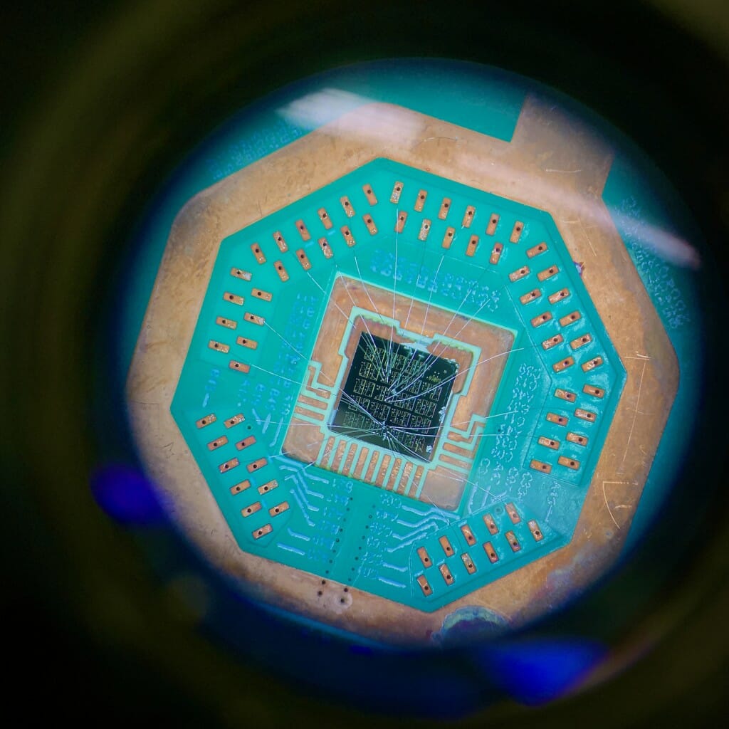 Viewed through the eyepiece of a microscope, aluminum wires one-third the diameter of a human hair connect superconducting devices to a microchip. During experiments, the microchip is cooled to -460 degrees Fahrenheit (just one-hundredth of a degree above absolute zero) to explore the laws of quantum physics and test nanotechnology for quantum computing.
Benjamin Harpt,
graduate student, Physics
digital camera