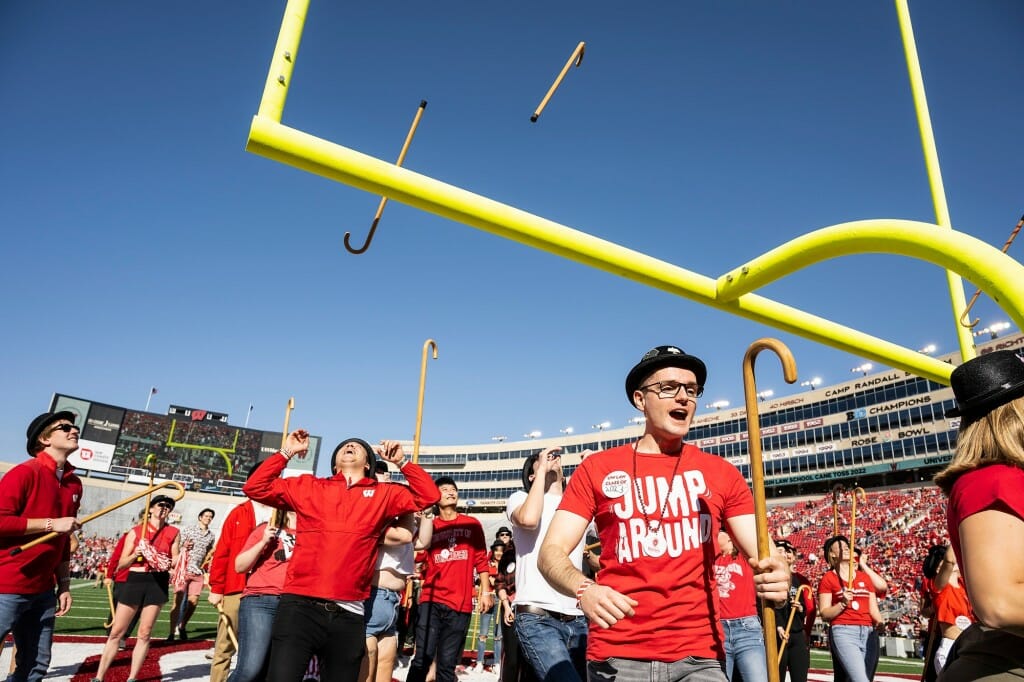 Part of an annual tradition, UW Law School students attempt to toss their canes over the south end zone goalpost and catch them before the start of the Homecoming game.