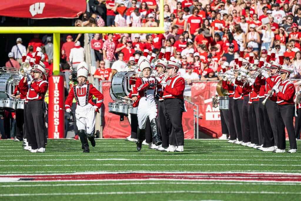A pair of drum majors lead the UW Marching Band in taking the field before the start of the game.