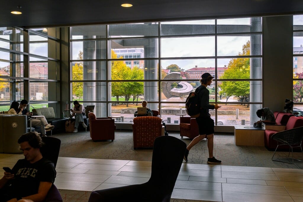 Students study and walk through a common area inside Engineering Hall.