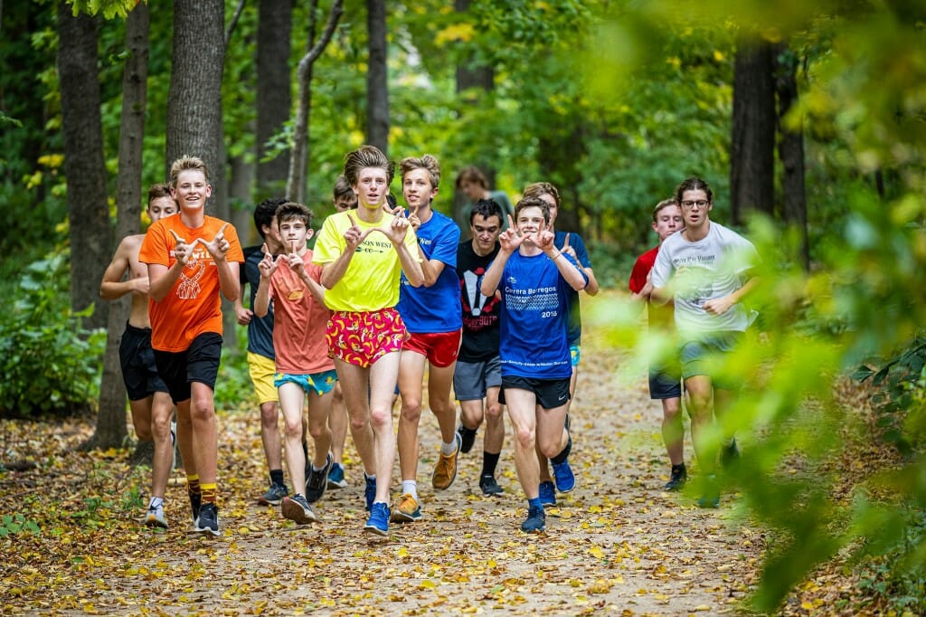 Members of the Madison West High School cross country team run along the Picnic Point path of the Lakeshore Nature Preserve on a fall day