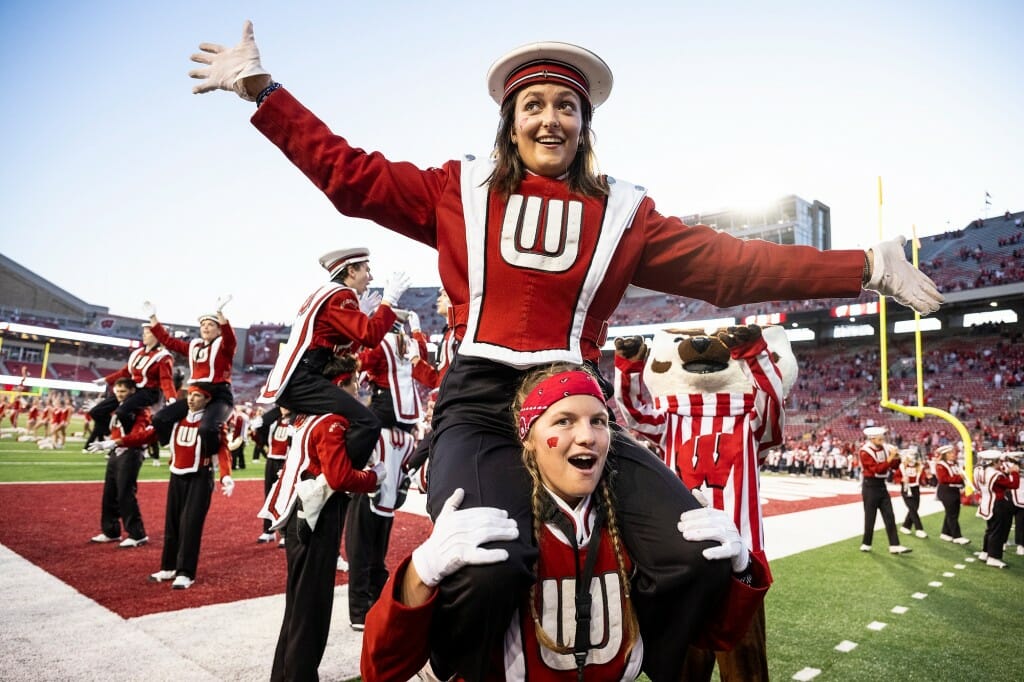 Marching Band members Maya Cherne (top) and Emma Eicher perform the chicken dance during the Fifth Quarter.