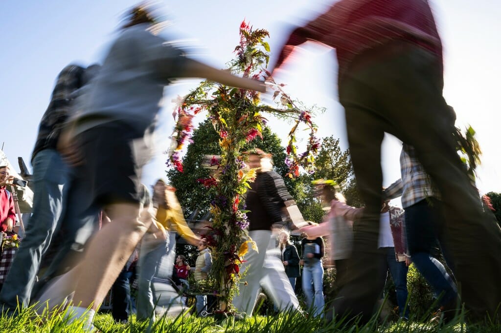 Adapting a Scandinavian summer tradition, people dance around a maypole decorated with autumnal flowers during the Harvest Folk Festival at the Allen Centennial Garden.