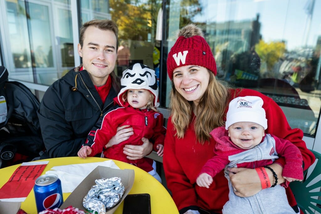 Siblings Tyler Young, an alumnus and graduate student, and Ashley Westphal, an alumna, pose for a photo holding Westphal’s two children (Harper, 2, and Teddy, 3 months) during a Badger Family Fest event.
