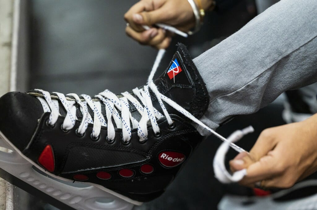 A close-up of ice skates being tied.