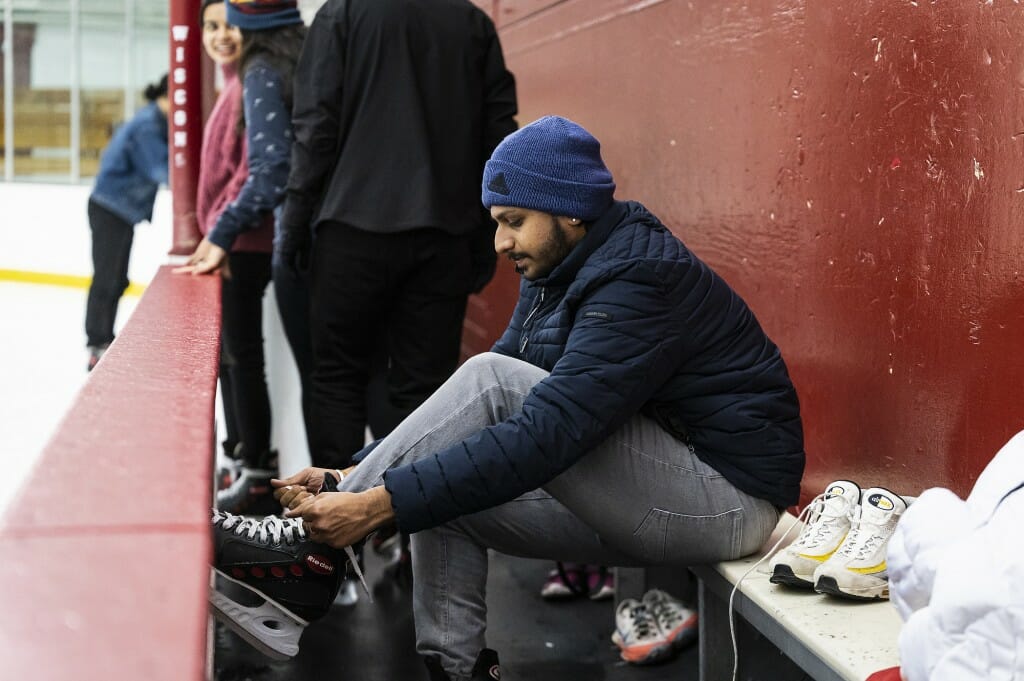 A man laces up his skates.