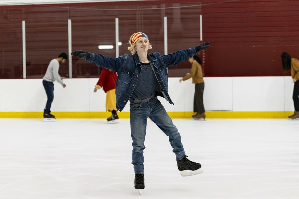 A man skates across an ice rink.