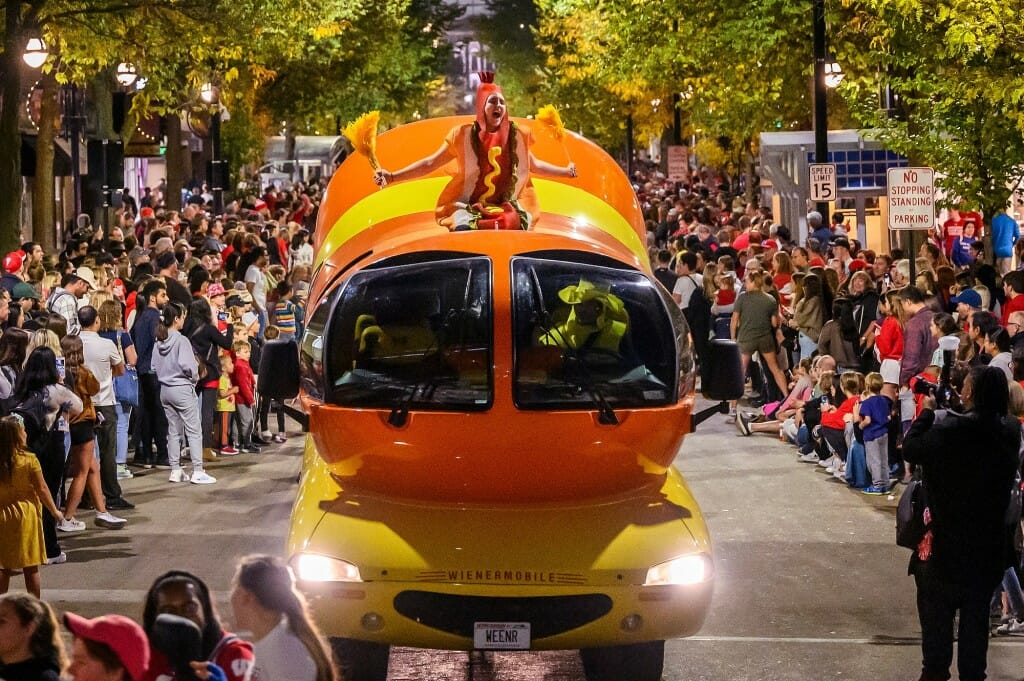 “Whoooo looovvvess HOT DOGS?” yells a person dressed as a hot dog while waving mustard-colored pompons and riding atop the iconic Oscar Mayer Wienermobile.