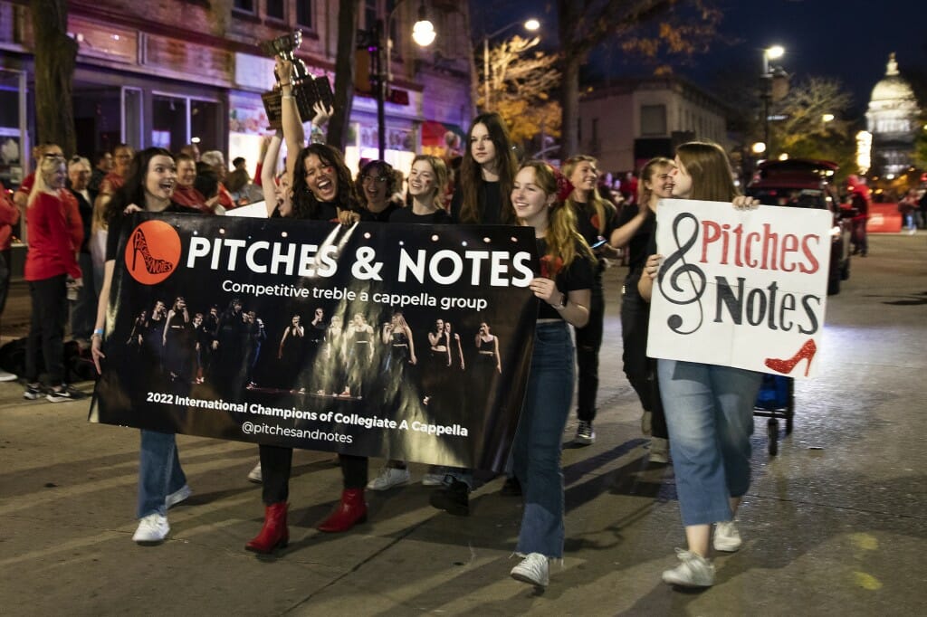 A group of young people carry a sign that reads 