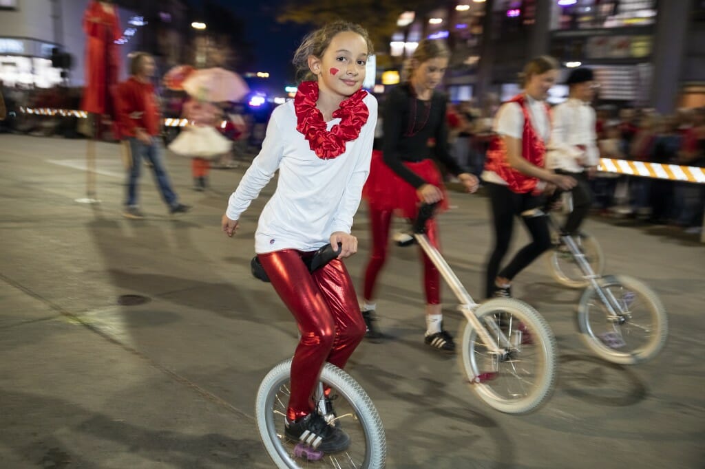 A woman rides a unicycle and smiles.