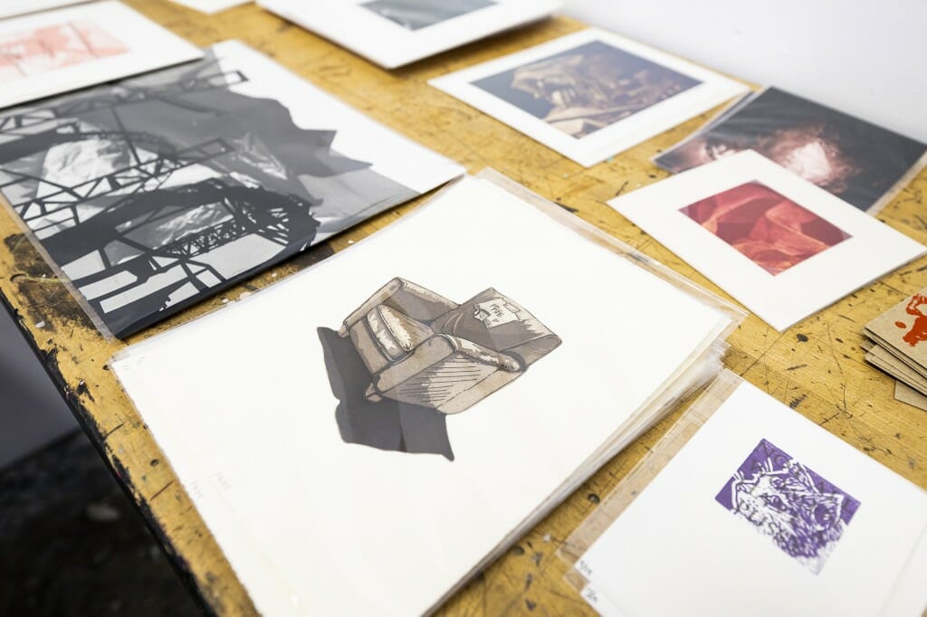 Some prints sit on a table, of all sorts.
