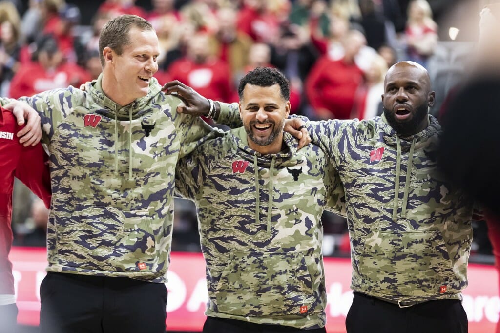 From left to right, Wisconsin men’s basketball coaches Joe Krabbenhoft, Dean Oliver and Sharif Chambliss link arms and sing “Varsity” after the Wisconsin Badgers’ 60-50 win over the Stanford Cardinal.