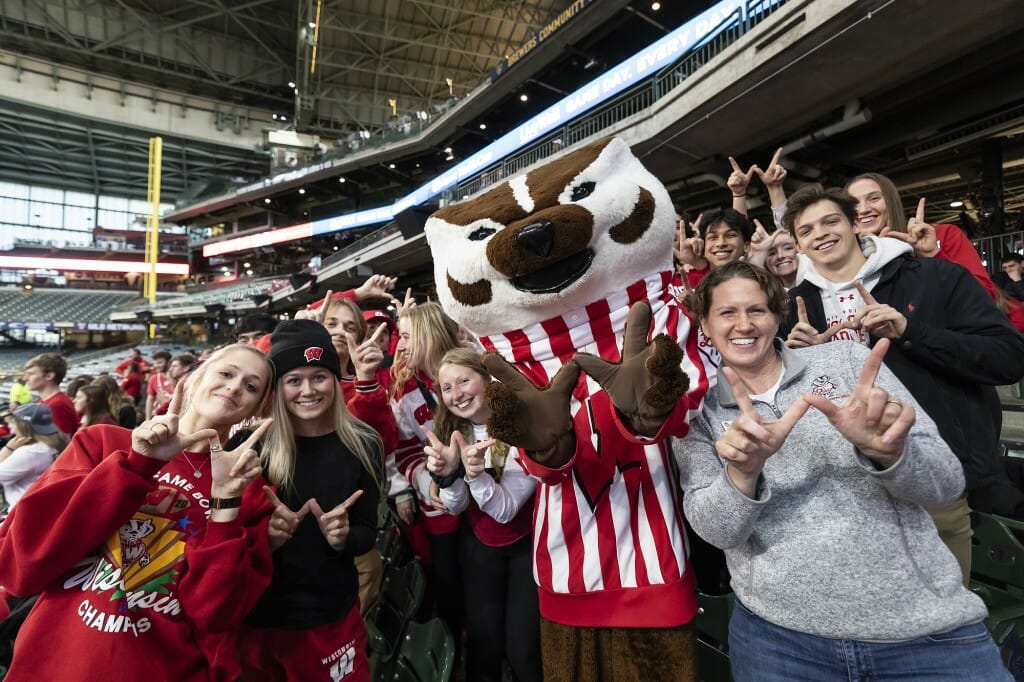 Bucky Badgers stands with dozens of fans in the stands.