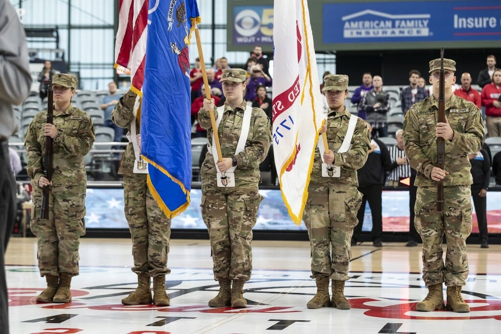 Members of UW–Madison’s ROTC hold flags for the national anthem before the start of the Wisconsin Badgers  women’s basketball game against the Kansas State Wildcats.
