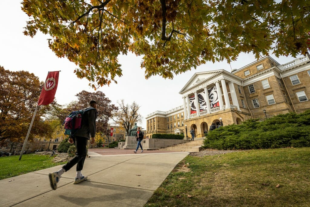 A student walks up the hill toward Bascom Hall on a fall day