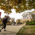 A student walks up the hill toward Bascom Hall on a fall day