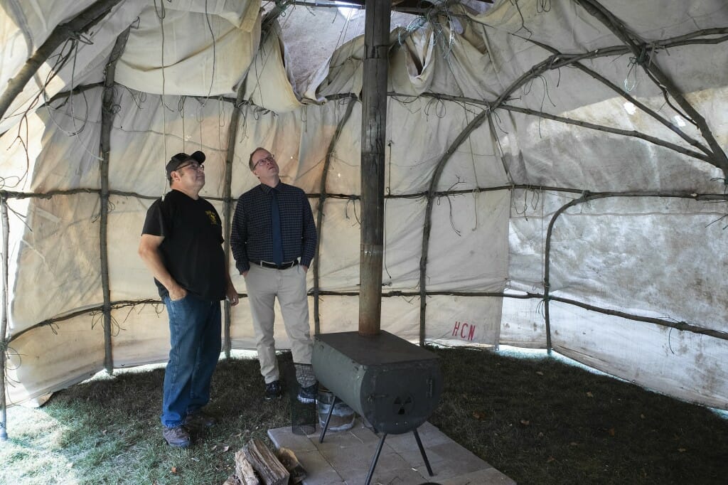 Bill Quackenbush, tribal historic preservation officer for the Ho-Chunk Nation, and John Zumbrunnen, vice provost for teaching and learning, talk inside of the ciiporoke.