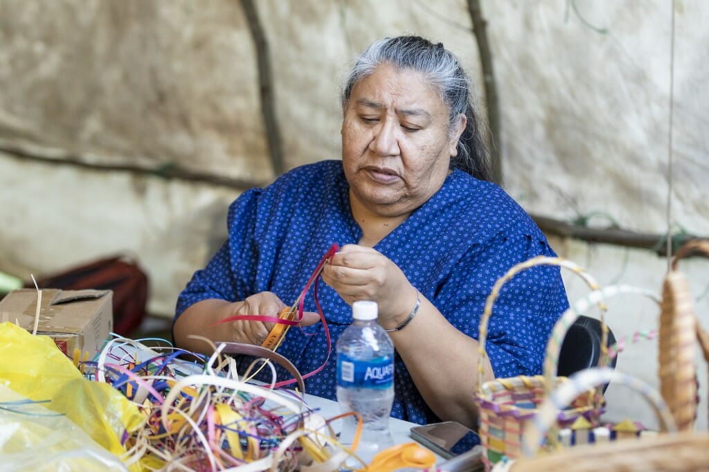 Kimberly Crowley, a Thunder Clan member of the Ho-Chunk Nation and a traditional black-ash basketmaker, instructs on how to weave the basket.