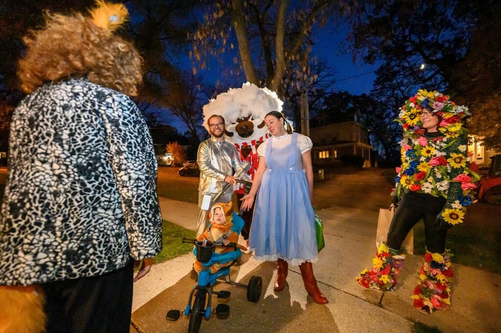 A family in Wizard of Oz costumes stop to talk with their new neighbor, Chancellor Jennifer Mnookin, on her first Halloween in Olin House.