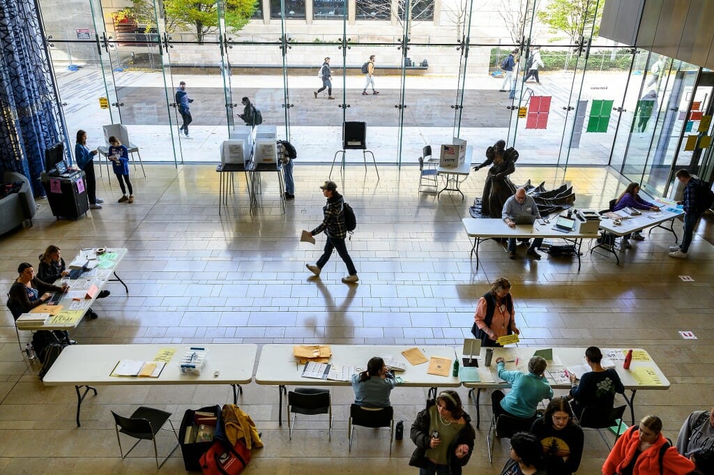A wide shot from above of students filling out midterm election ballots and registering their vote at the Chazen Museum of Art
