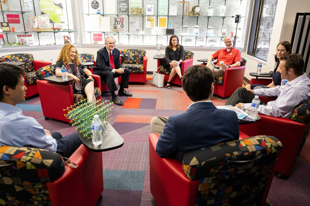 Chancellor Jennifer Mnookin and College of engineering faculty sit in conversation in a circle of red armchairs.