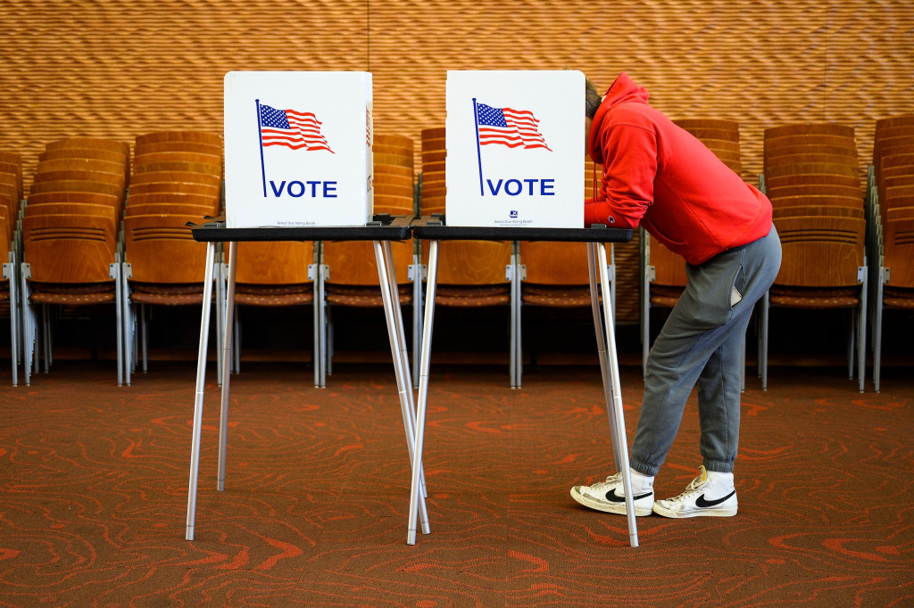 A voter leans into a polling booth to cast a ballot in the 2022 midterm elections.