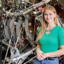 Grace Stanke pictured with the HSX fusion experiment at UW–Madison.