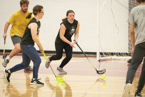 Emily Kollmann, left, passes the ball to Brynne Breck during a floorball match.