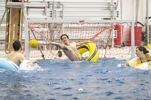 Sawm Djamali lunges to defend the goal during an inner-tube water polo game.