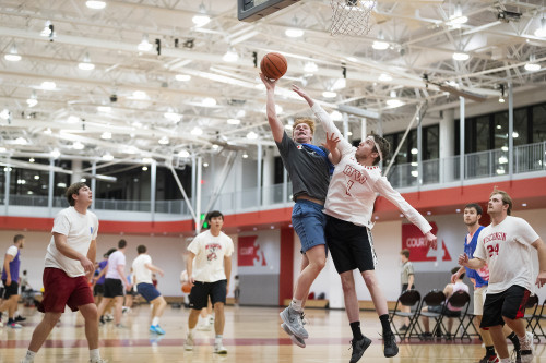 Two students jump for the ball in an intramural basketball game