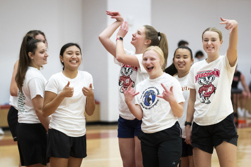 Seven students pose and cheer during a break in an intramural basketball game