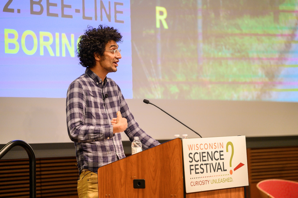 Latif nasser stands at a podium and speaks to an unseen audience.