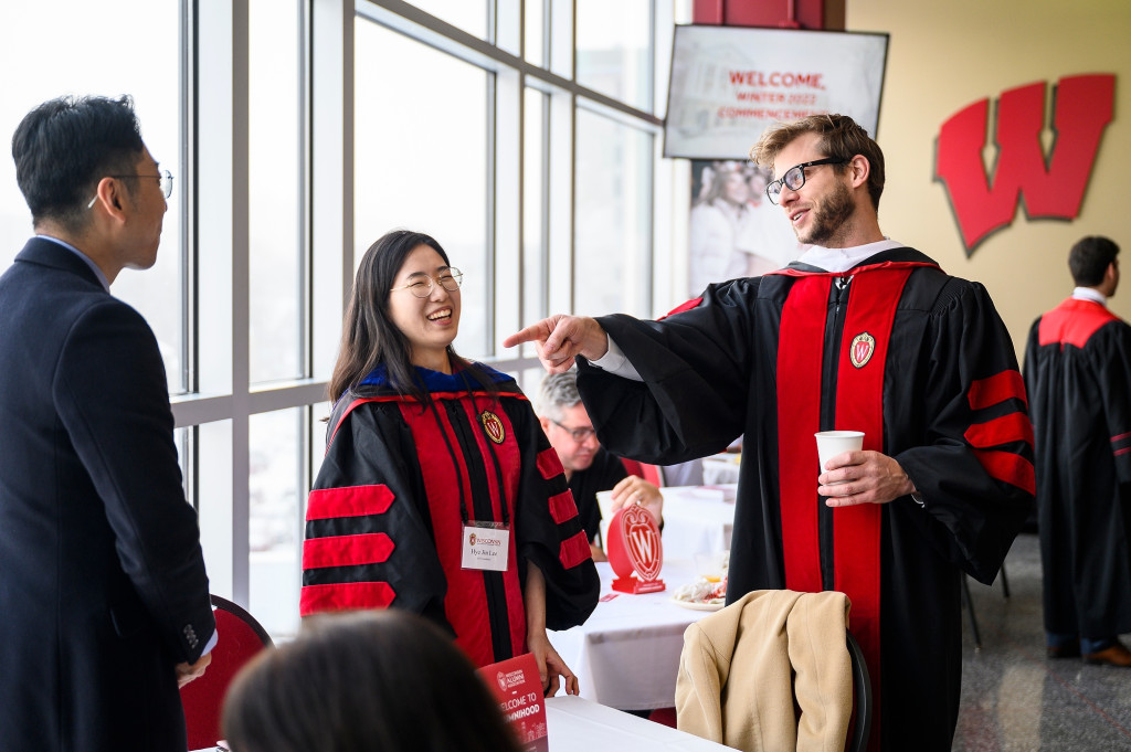 Commencement keynote speaker Charlie Berens meets with graduating students, including Hye Jin Lee, before the ceremony held in the Kohl Center.