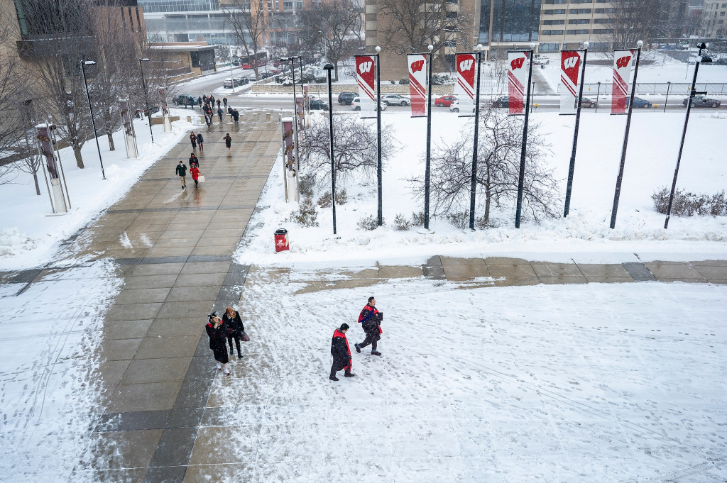 Graduates and their supporters walk toward the Kohl Center for the winter commencement ceremony.