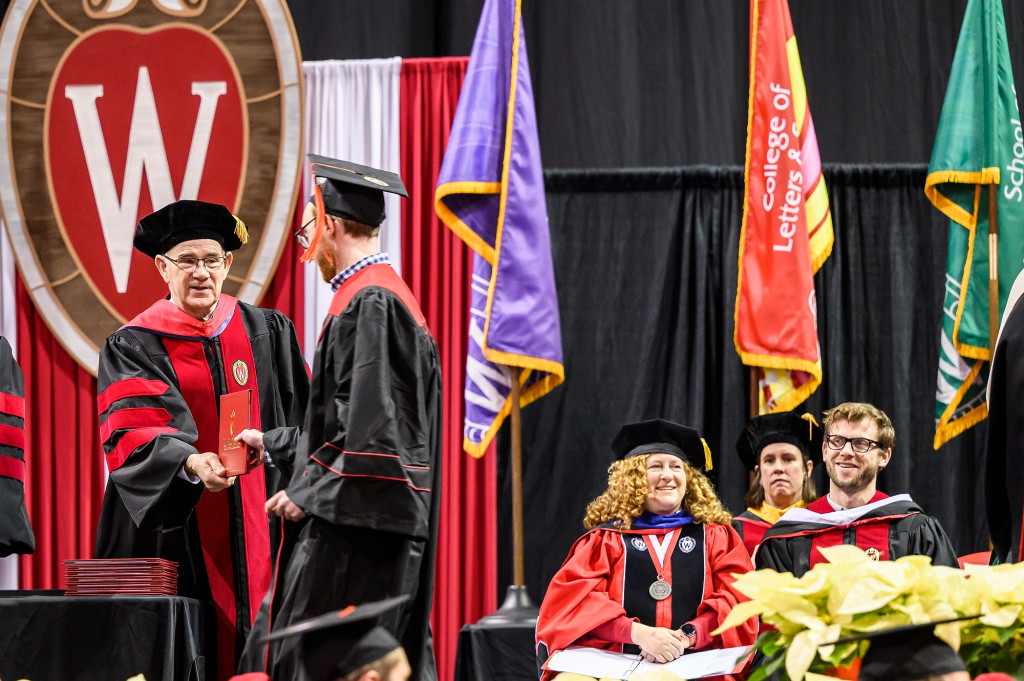At left, Ian Robertson, dean of the College of Engineering, hands out diplomas to graduates.