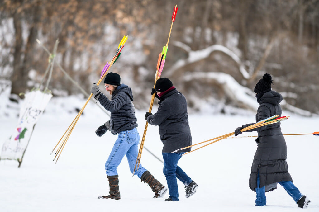 Ojibwe Winter Game participants retrieve lances.