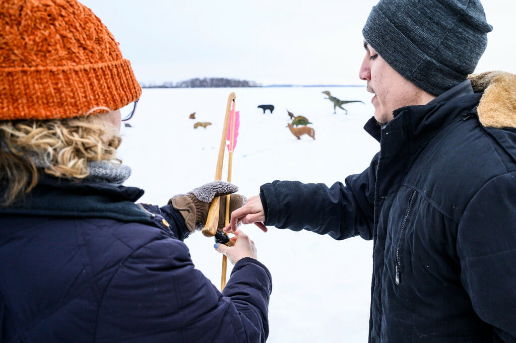 Spencer Smith, an apprentice of Wayne Valliere, right, shows Michelle Konkol, a fourth-grade teacher from Stevens Point, how to use an atlatl (spear thrower). The atlatl was a precursor to a bow and arrow and allowed the hunter to throw a dart or spear from a farther distance.