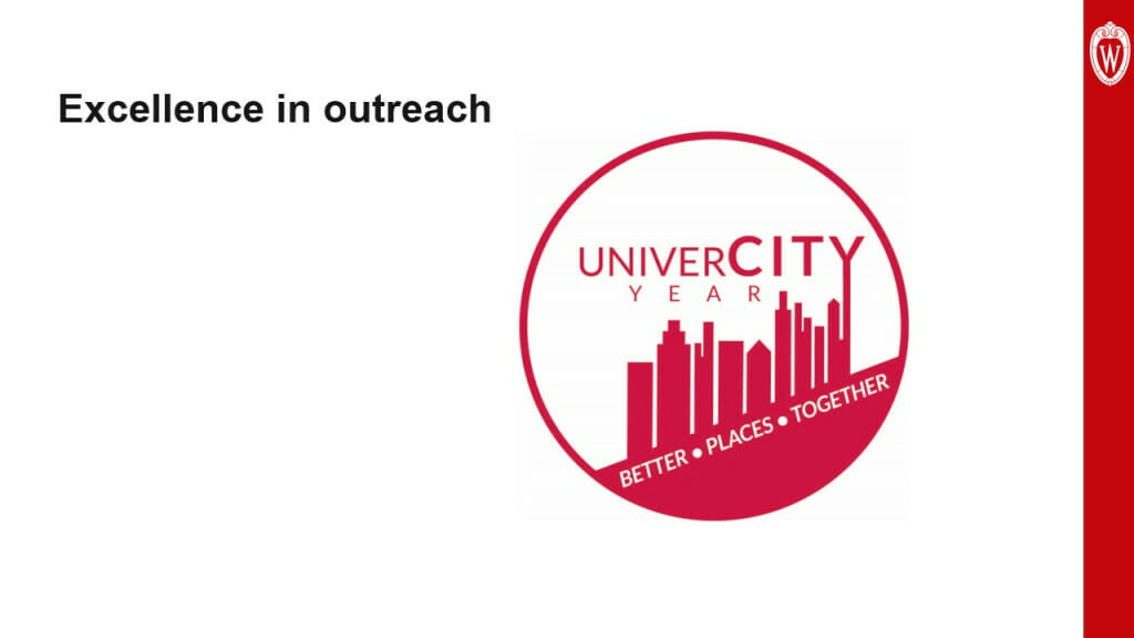 This slide is titled “Excellence in outreach.” It shows the logo for UniverCity Year” a red circle containing the text “UniverCity Year” and “Better Places Together.” Also inside the circle is the outline of a city skyline.