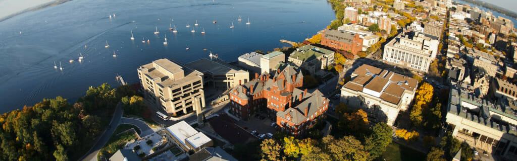 The University of Wisconsin–Madison campus is pictured in an aerial view looking east toward the downtown Madison skyline during an autumn sunset