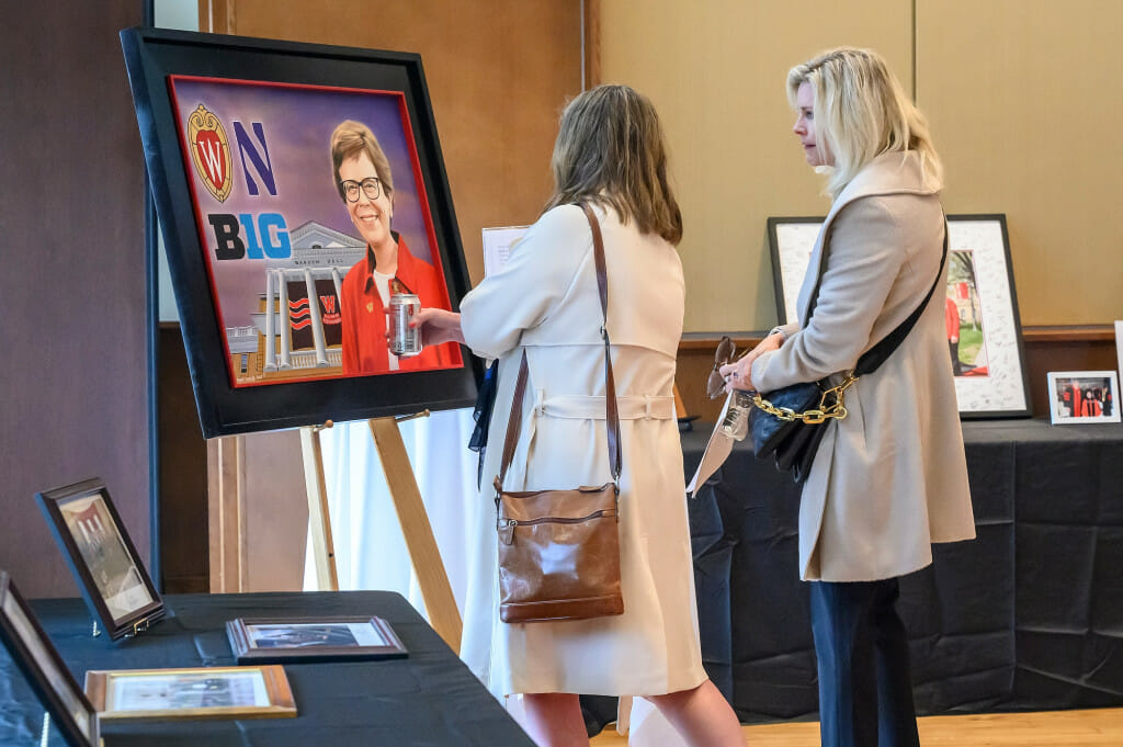 Two women look at a portrait of Chancellor Emerita Blank.