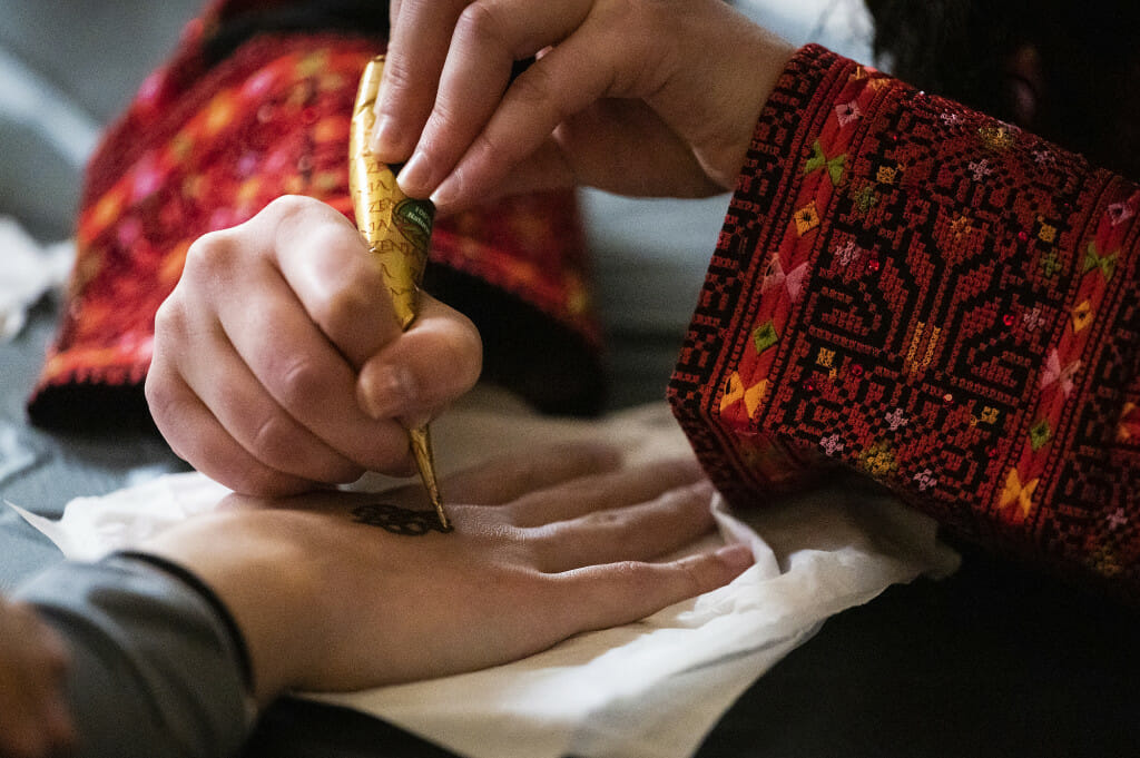 Maha Mustafa painstakingly creates a henna decoration.
