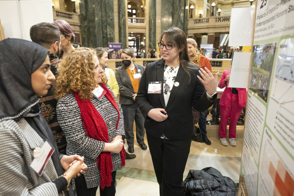 UW–Madison Chancellor Jennifer Mnookin (center) listens as UW–Madison students Sarah Almutawa (left) and Isa Butz (right) talk about their research project, titled 