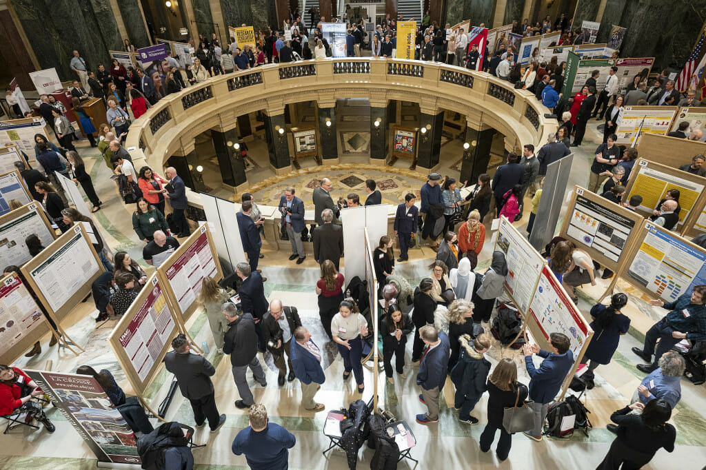 UW-Madison students, at bottom, present their research project displays as people fill the Wisconsin State Capitol during Research in the Rotunda on March 8.