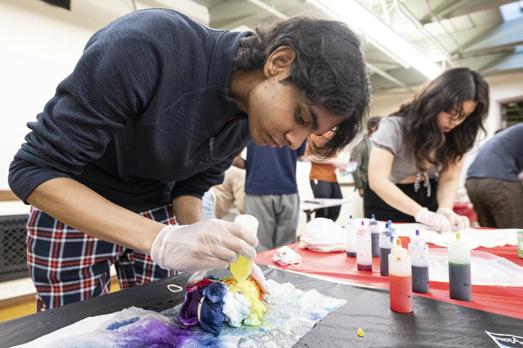 UW students Shrey Dekate (left) and Rachel Nguyen (right) use tie-dye inks to decorate t-shirts.
