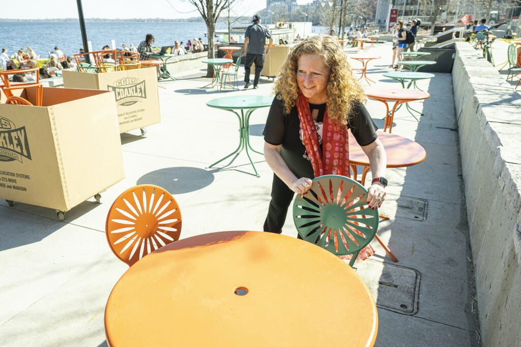 Jennifer Mnookin sets out a green metal chair on the Memorial Union Terrace.