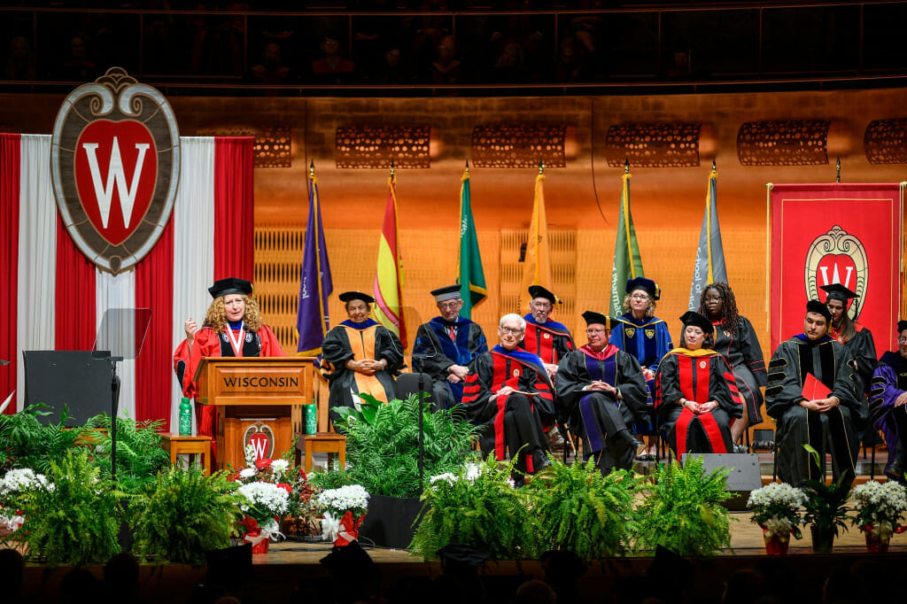 Chancellor Mnookin stands at a podium addressing a large crowd.