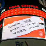 Words of thanks in multiple languages are displayed on the scoreboard at the Kohl Center.