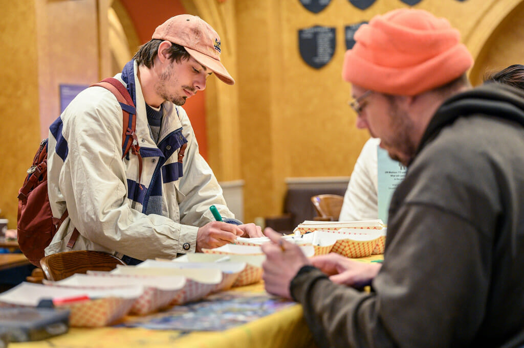 At left, undergraduate Maxwell Reed decorates a four-inch-square, mini-canvas.